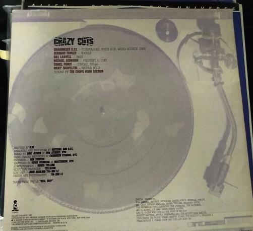 Back cover of Crazy Cut vinyl record, with a shaded background representation of a turntable, a proper instrument in the context of this album