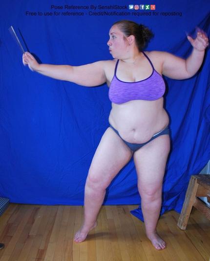Person is standing up with one hand pointed towards their left and they are holding what seems to be a wand. They are in a stance as if they are about to put a spell on someone or something.