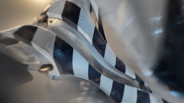 3D render (from 2013) of a generated, sliced gyroid surface, using different materials (metallic inside, black & white striped outer layer). Strong depth of field.