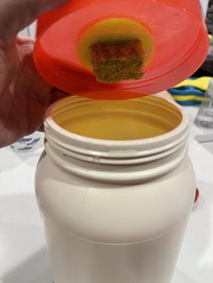 putting the pool noodle/ rock wool into the lid. showing how the rockwool hangs down into the bin.