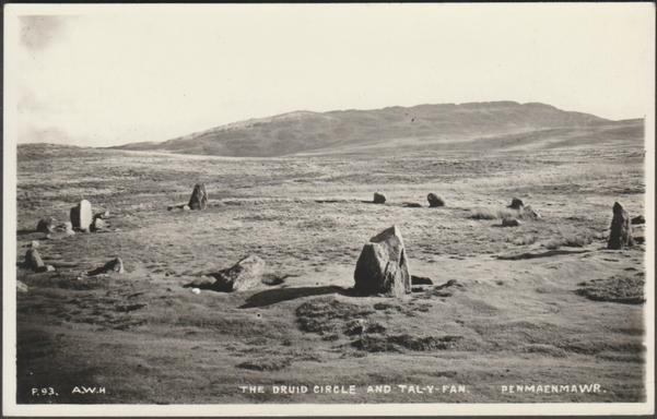 A vintage postcard showing the prehistoric stone circle called the Druids' Circle or Cefn Coch at Penmaenmawr in North Wales. The Tal-y-Fan hill rises in the background.