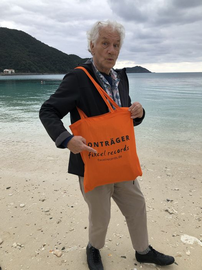 Mani Neumeier in Okinawa am Strand mit fixcel records Tasche