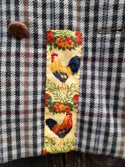 Two roosters on a long stripe applicated at the right side at the bottom.