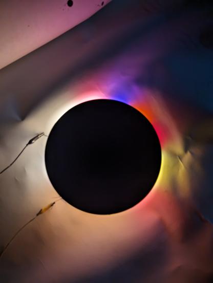 A ring of different colors of light with a black plastic circle atop it. We have black plastic circles for the class.