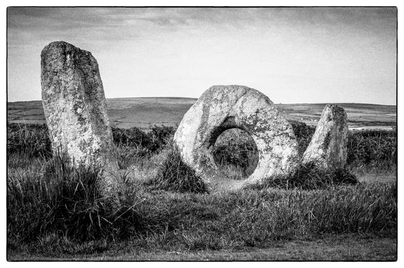 Three standing stones, the central of which is circular with a holed centre. They stand about 1.2m high on open moorland.