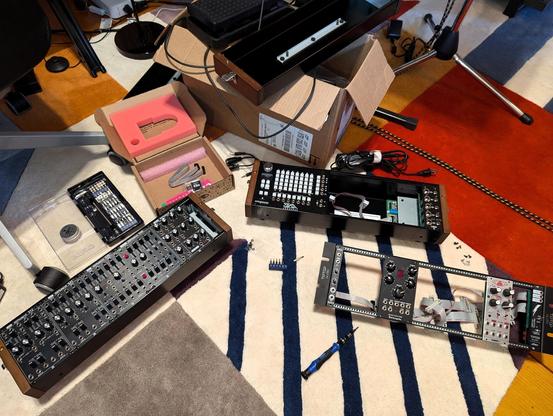 Various eurorack modules in the process of being installed into an empty rack.