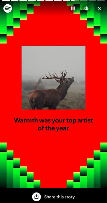 The image features a deer looking upwards against a misty background, set on a vibrant red background with green graphical elements. It includes text that reads "Warmth was your top artist of the year."