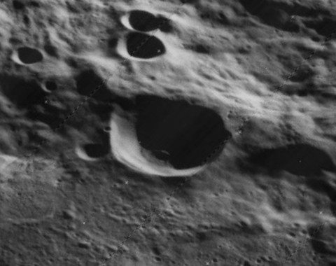 WikiCommons B&W photo is of the Kearons Crater on the far side of the Moon. Dated 1967 & 2015, from Lunar Orbiter 5. 
Processed by James Stuby of a NASA image.  

Basically, a gray Moonscape with a larger crater at center, surrounded by a variety of smaller craters. Image intended to evoke thoughts of remote Time.

https://commons.wikimedia.org/wiki/File:Kearons_crater_5015_h1.jpg