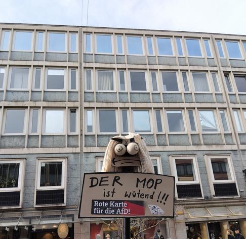 Ein Mop mit Augen und minderbegeistertem Mund
und dem Schriftzug: Der Mop ist wütend!!!

und "Rote Karte für die AfD"