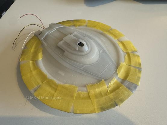 Saucer section with yellow masking tape applied around the edges to hold the two parts together.