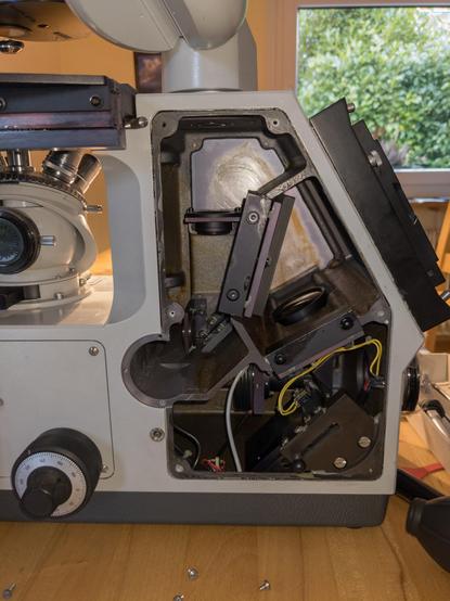 Side view of the microscope with one of the covers open. The inside shows several mirrors and lenses redirecting the light to the different output ports.