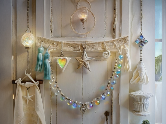 A cozy bohemian room holds a rustic wooden door, layered with many years of coats of white paint, and permanently held closed by decorations including delicate macrame, strings of hanging iridescent glass spheres and beads, and various eclectic ornaments.