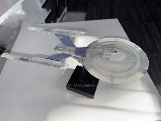 An unpainted model on its base.
