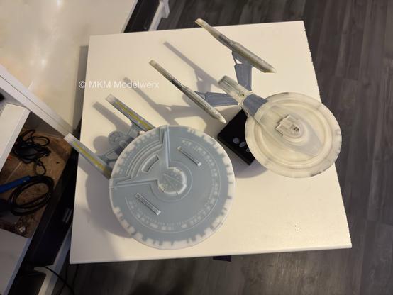 Looking down at the tops of two unpainted models sitting on a white table.