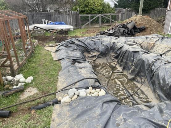 I look at the backyard. It's a bit of a disaster. But there is progress. The large pool is empty now as is the other two smaller holes. All of the extra rubber and garden liner is in a pile beside the dirt. The garden boxes have been removedcompletely as the mail felt that was underneath the car. There is fresh dirt turned over it all needs to be leveled.