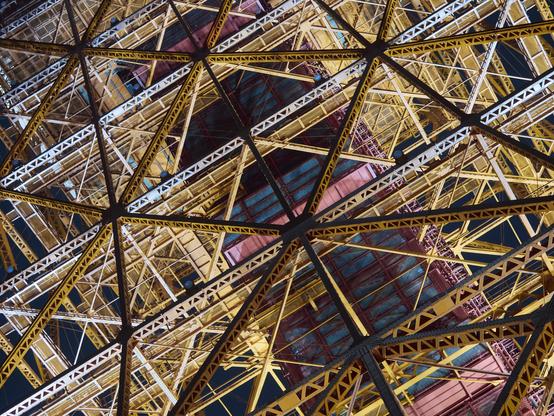 A tight shot of Tokyo Tower at night, the orange glow of the city lights contrasting with the brighter flood lights. The tower feels more like it is a part of something like a space ship, with all of the C-Beams glittering in the dark.