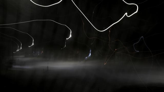An almost black photo with scribbly lines of light drawn across the dark background.