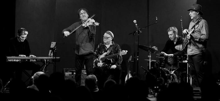 De gauche à droite sur scène, Philippe au clavier, François au violon, Jean-Marc à la basse, Cédric à la batteries, Éric à la guitare (photo en noir et blanc)