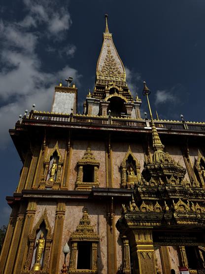 Looking up at Wat Chalong main building. Gold buddhas and ornaments everywhere.