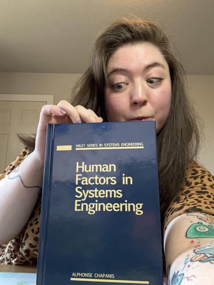 paige holding up the book curiously peeking inside