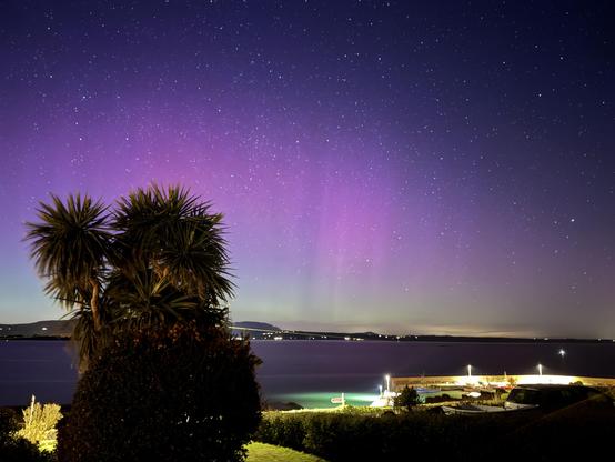 Aurora over Dungarvan bay looking towards Bonmahon from Helvick. 

Lots of purple and green covering most of the sky.