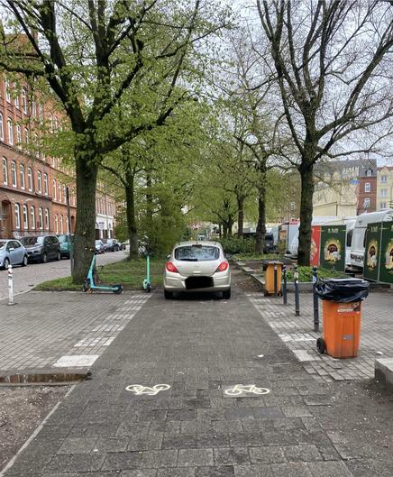 Ein Auto wird über eine Radweg gefahren.