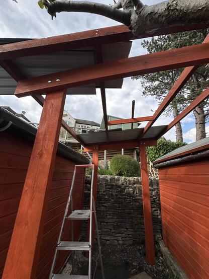 My wood store. The roof frame is on and there are some roof sheets sitting on top.