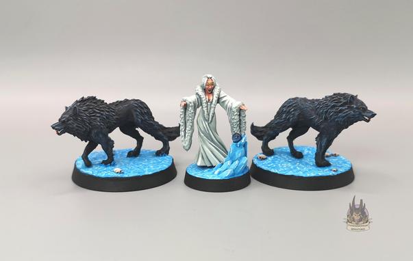 A vampire queen in white robes and headdress, flanked by two giant black wolves