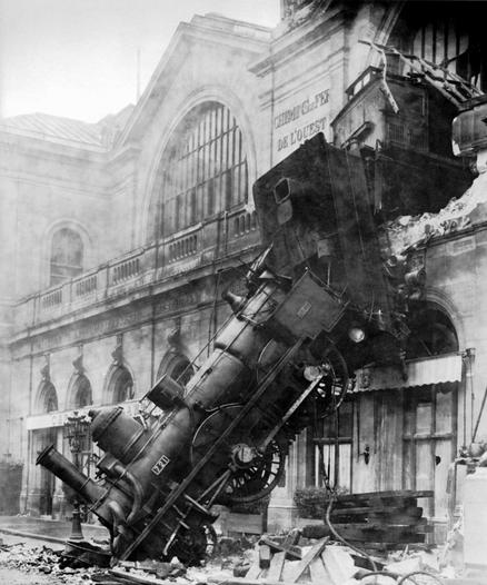 Locomotive angled down in the pavement, having crashed through the railway station wall high above.