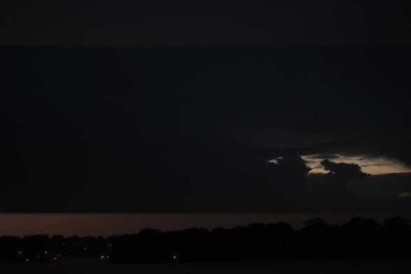 The camera captures the glimmer of lightning illuminating both the upper and lower sections of the frame