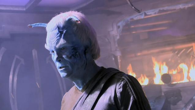 Shran with fire burning in background of the ship