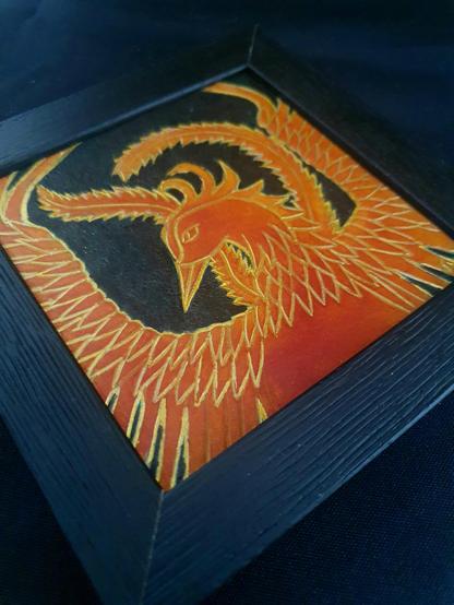 Frame of a phoenix, hand-tooled and hand-dyed veg tan leather, aqueous dye and gold ink.