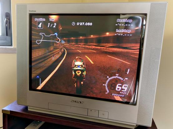 My curb-found Sony KV-21FX30E from 2001, showing "Tourist Trophy" (2006) for the PS2. It's silver and everything in it is right angles, at least when viewed from the front. Pehaps as a nod to its flat-faced picture tube.