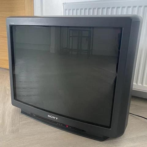 A Sony KV-X2972U from 1994. It's black and with slighly rounded corners. The speakers have slim grilles angled towards the back. It has a strip of dark (almost black) red translucent plastic below the screen (vertically flat but slighly curved horizontally Trinitron). Behind the strip there are three rather large square LEDs (power, and two stereo NICAM left-light indicators) and a panel with some RCA inputs and buttons.

This is a random picture from the Internet. Well... not so random because it took me a while to find one of this specific case design, which matches the one my parents had (albeit this one is larger, I believe).

There were contemporary ones with speakers hanging off the sides, which looked cool at the time but haven't aged as well.