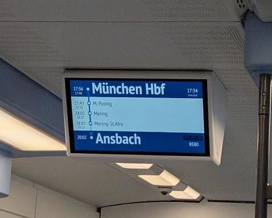 Eine Haltestellenanzeige in einem Averio Zug. Der Zug fährt von München nach Ansbach. Auf der rechten Seite ist über der Zugnummer RE80 die Anzeige mit einem Streifen blauen Tape verdeckt.