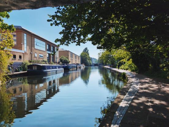 Regents Canal on a sunny day, framed by a bridge