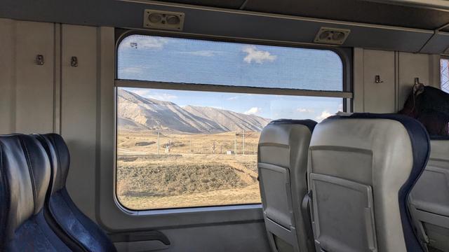 Sight out of the windows of mt local train. There are hills behind another railway track.