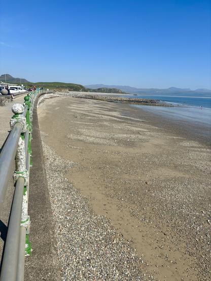 View from the promenade across the quiet beach towards Yr Eyri.