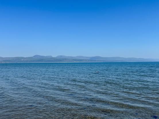 View across the sea from the beach with the mountains of Yr Eyri standing out.