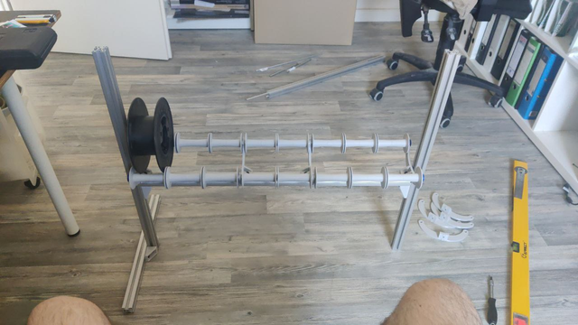 A Filament Rack with currently 8 Slots for Filament spools.
The Spools are resting on two rollers each which help them spool down when in use. The Rollers have a small chamfer to help the spools keep somewhat centered