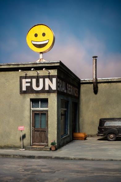 a photo of a miniature set showing a bland concrete building with a door, above which is a sign that reads "FUN" with a big yellow smiley-face sign on top of the roof