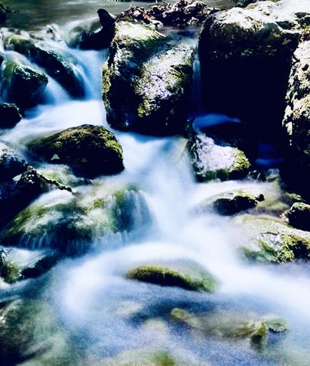 Photo closeup of small set of cascading waterfalls in mountain stream. The water is rushing over and around moss-covered boulders.  Several shadows are cast over the boulders due to the bright sun shining through this forested area.

I took this photo while hiking last week in Western Massachusetts.

Alander Mt Trail, Mt Washington State Forest, Massachusetts.