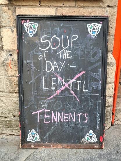 A chalk board outside a Glasgow pub which reads Soup of the Day Lentil. The word Lentil has been crossed out and replaced with the word Tennent's.