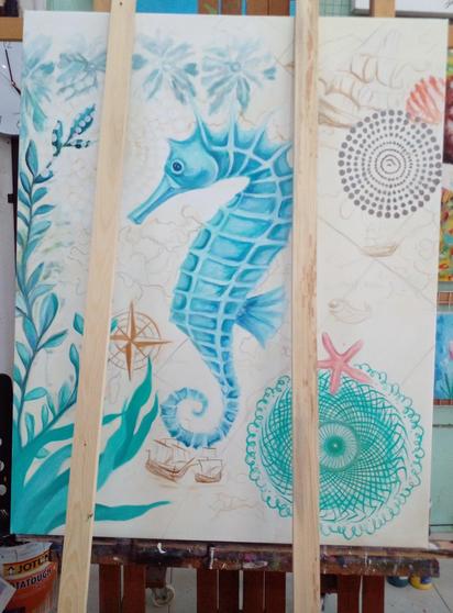 a painting, it is half-finished, it is of a teal blue seahorse in the center, around it are aquatic plants and designs and decorative elements, on a light tan background