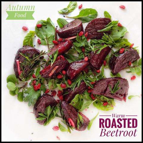 The image features a vibrant and appetising dish of warm roasted beetroot. The beetroot is cut into large, irregular chunks and is arranged on a bed of fresh green leaves. The beetroot has a deep, rich red colour, indicating it has been roasted to a tender consistency. Scattered throughout the dish are goji berries, adding a pop of colour and texture. Fresh herbs are sprinkled over the beetroot.
