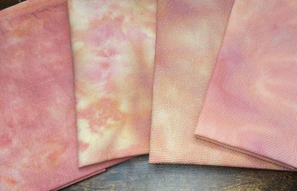 Linen, Evenweave, Opalescent Aida, and Aida fabric with a bright pink and yellow marbling.
