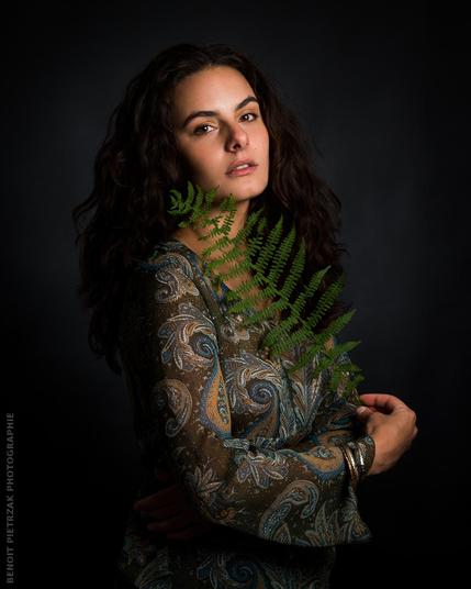 portrait photo en studio d'une femme avec une feuille de fougère