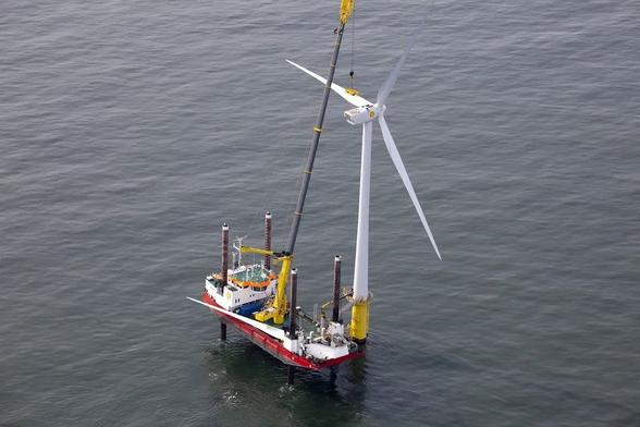 A vessel works alongside a wind turbine at the Shell NoordzeeWind offshore wind farm