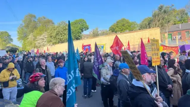 A large crowd in the streets, carrying flags
