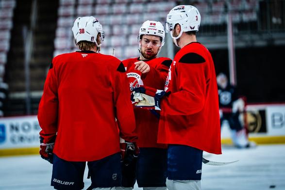 Andrew Mangiapane has a discussion with Matt Roy and Rasmus Sandin.